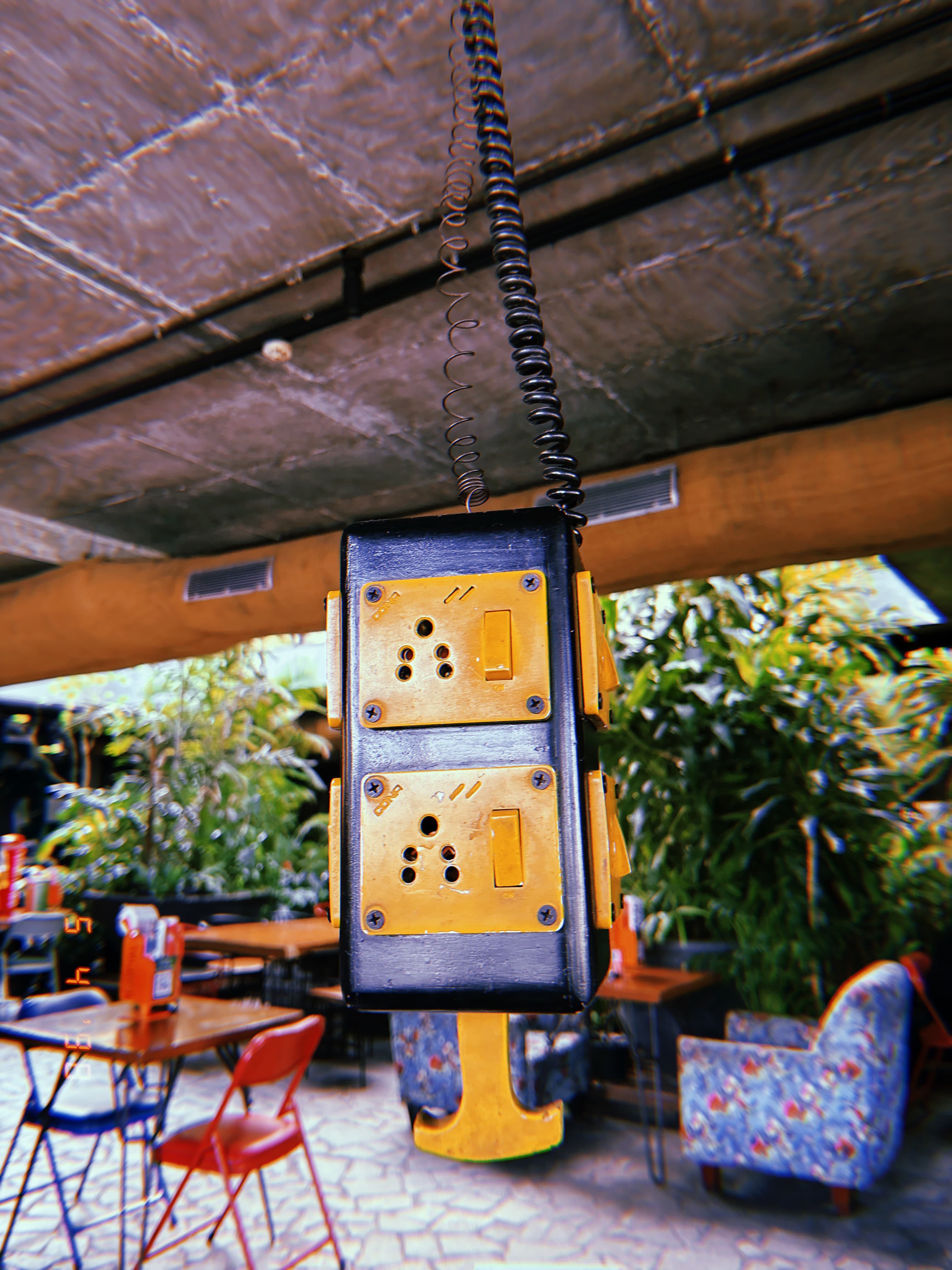 A power socket hanging from the ceiling of a cafe